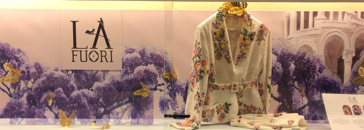 Printed shirt displayed among flowers beside the Là Fuori logo.