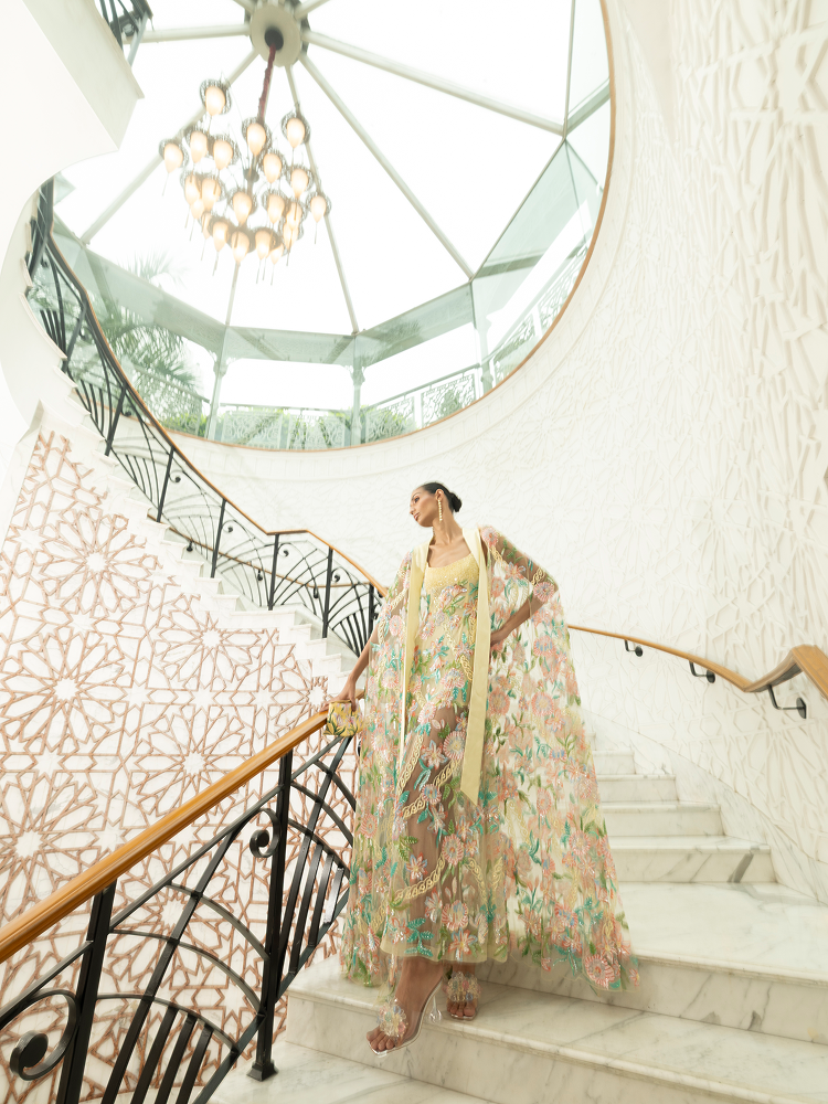 Destination party outfit featuring a beaded cape with hand-embroidered floral motifs for evening events