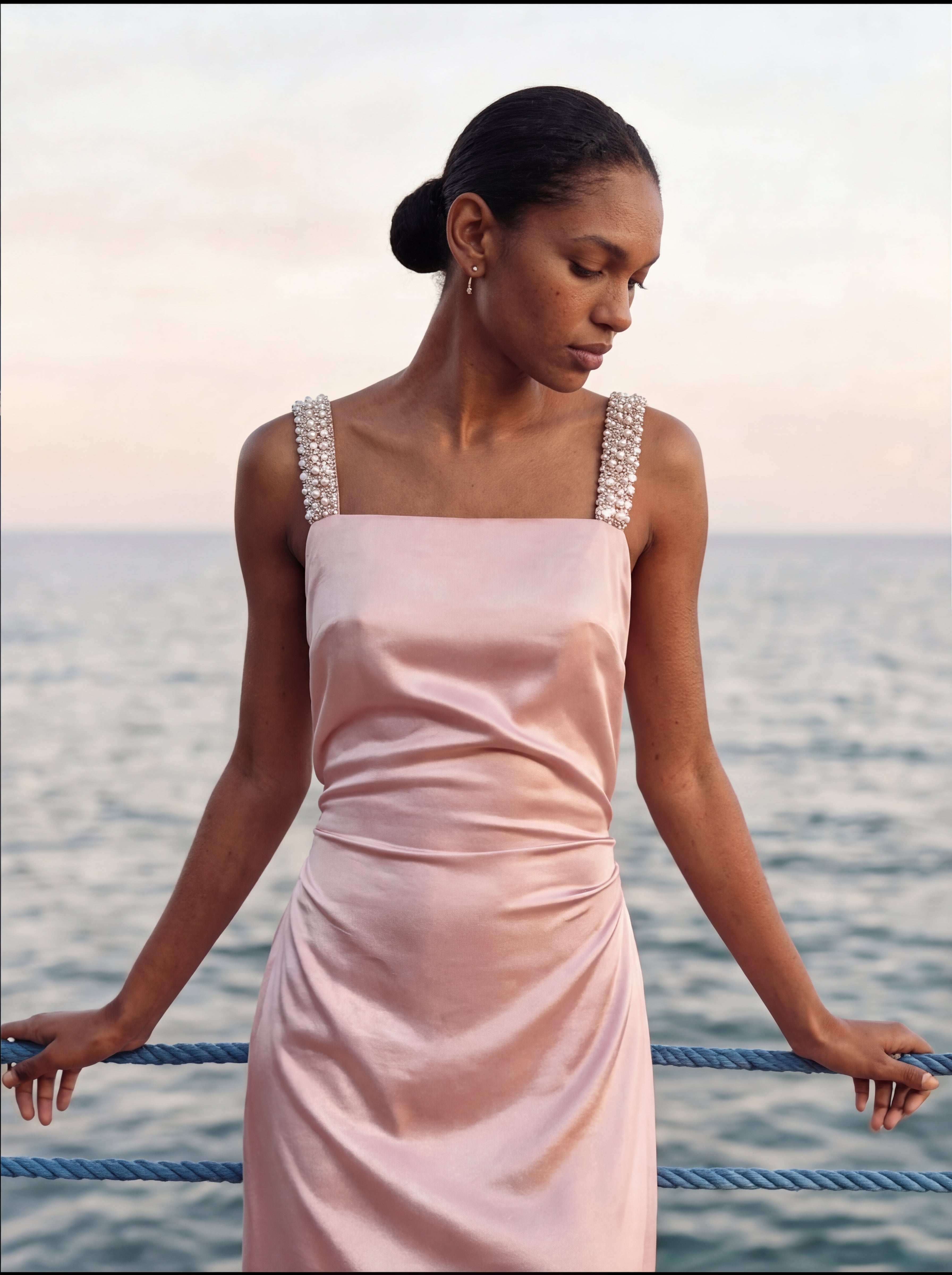 Woman in a pink dress standing by the water