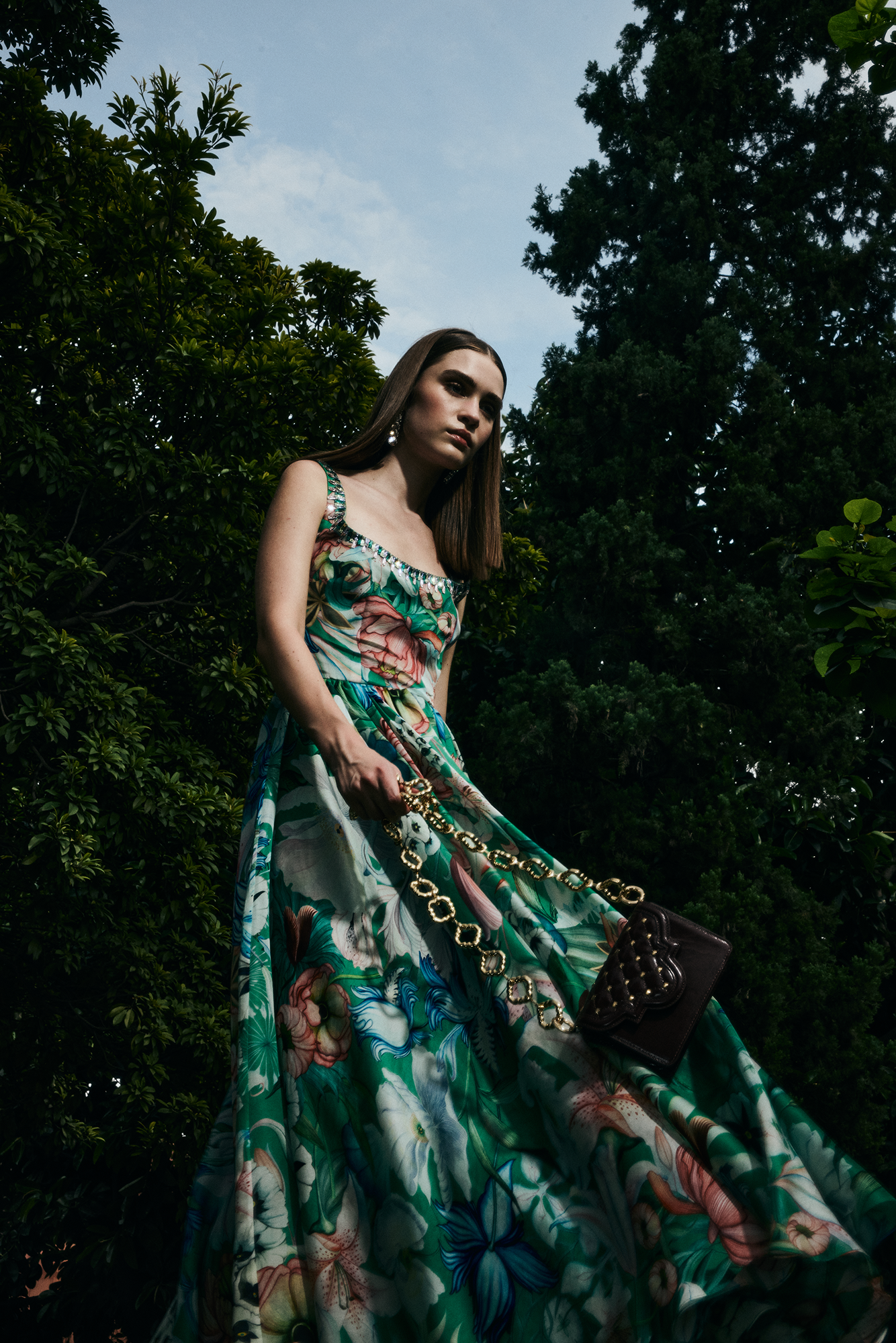 Woman in a floral dress standing among trees