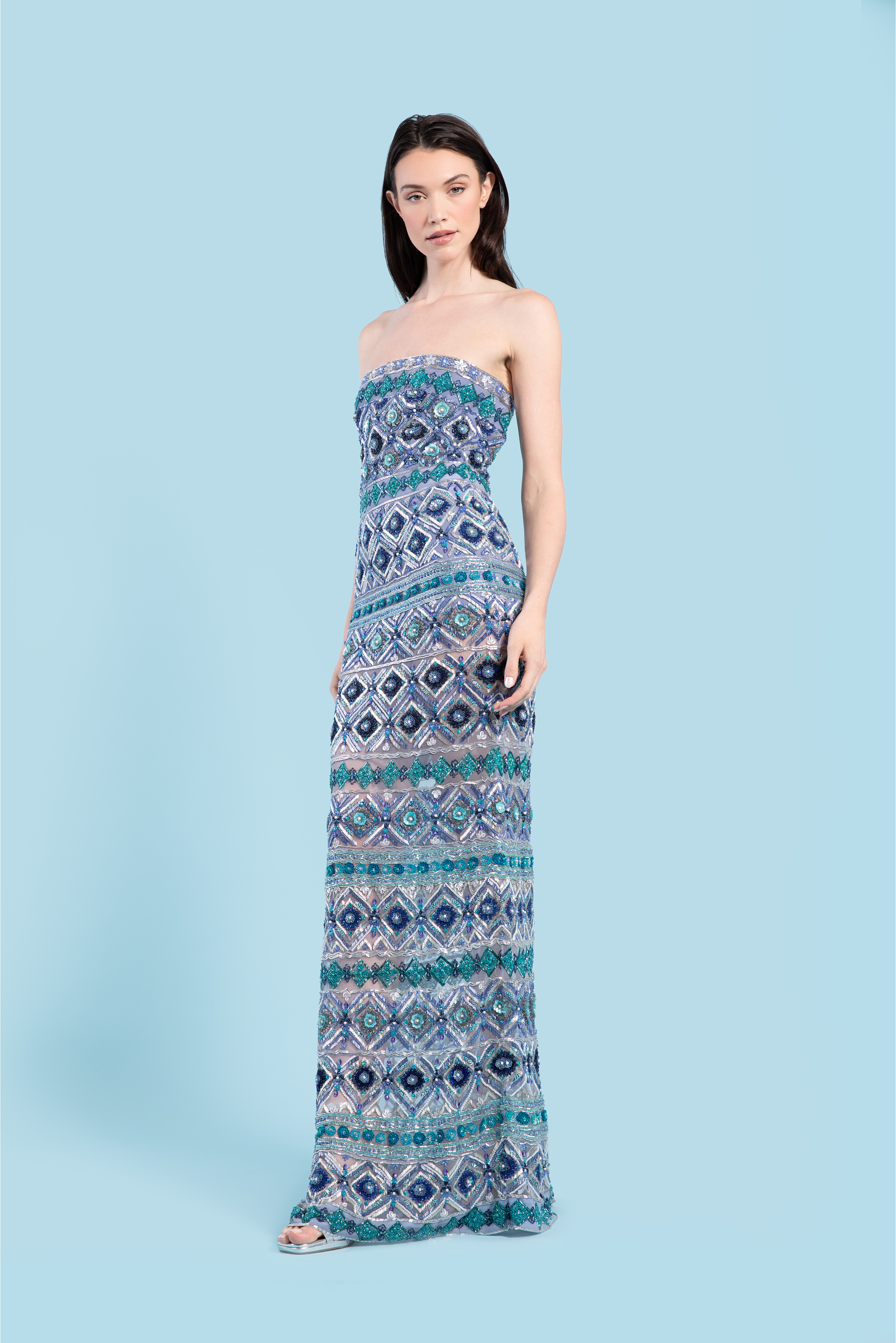 Woman wearing a strapless, patterned dress on a light blue background