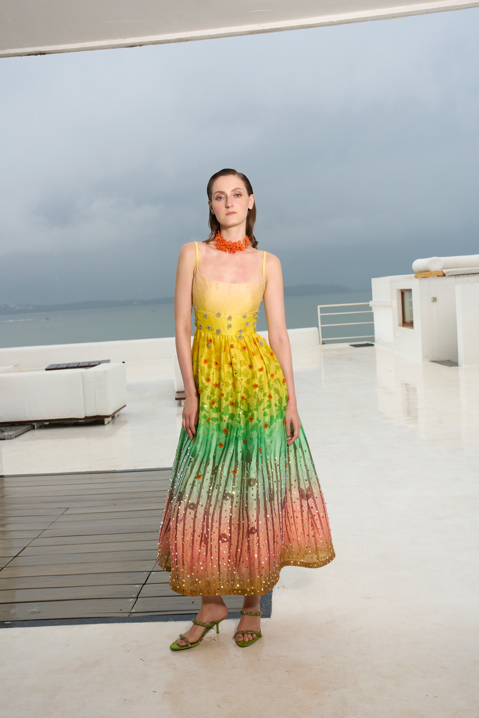 Woman wearing a colorful dress on a rooftop with ocean view