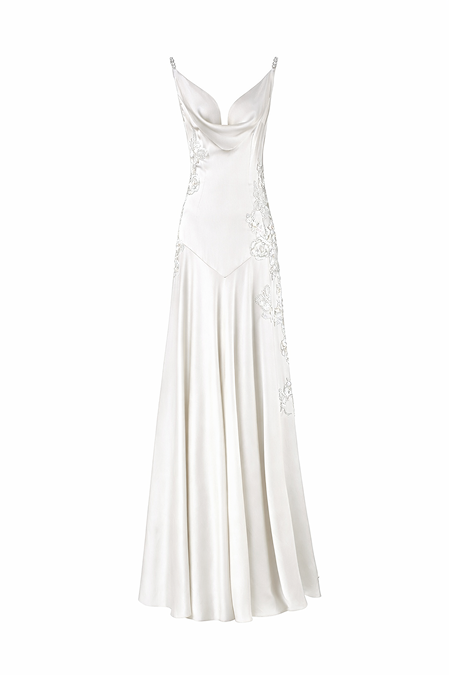 An off-white satin evening gown with a cowl neckline, spaghetti straps, and intricate floral lace appliques on the bodice and skirt, shown against a plain white background.