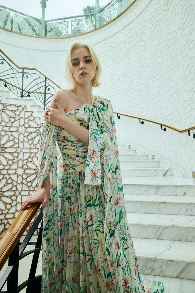 Sheer cape overlay with tie-up cape accents on a floral cape gown silhouette