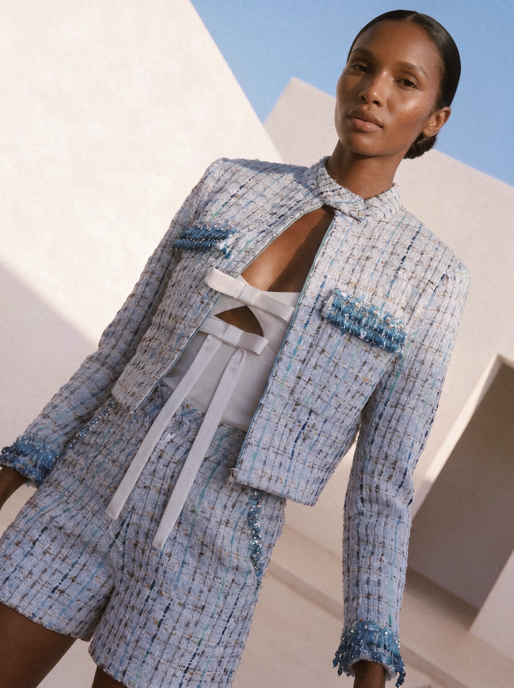 Woman wearing a blue and white patterned outfit with a white background